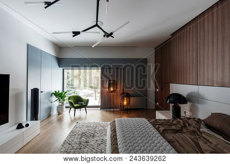 Modern Bedroom With White Walls And A Parquet With A Carpet On The Floor. There Is A Bed With A Brow