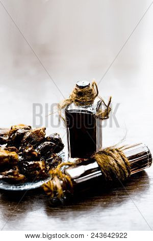 Sweet And Floral Essence Of Date Or Khajoor In Bottles On Wooden Surface Used I Flavored Chocolate A