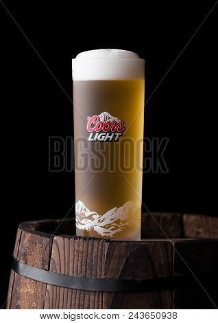 London, Uk - June 06, 2018: Cold Glass Of Coors Light Beer On Old Wooden Barrel On Black Background.
