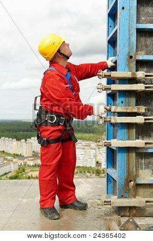 worker mounter assembling concrete formwork at construction site