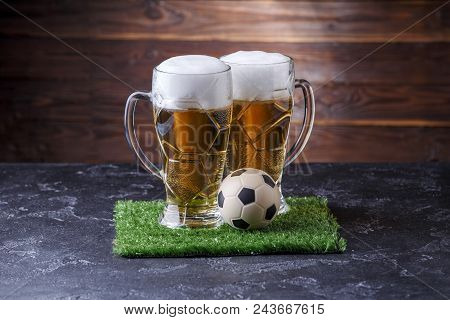 Photo Of Two Beer Mugs, Green Grass With Soccer Ball On Wooden Background