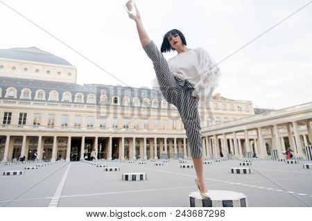 Young Stylish Woman In Pants With Split On Street In Paris, France. Dace And Yoga Concept. Dance Pos