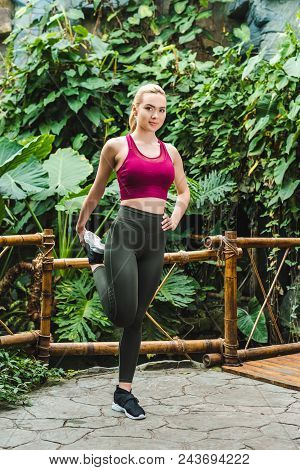 Athletic Young Woman Stretching Legs Before Training In Park