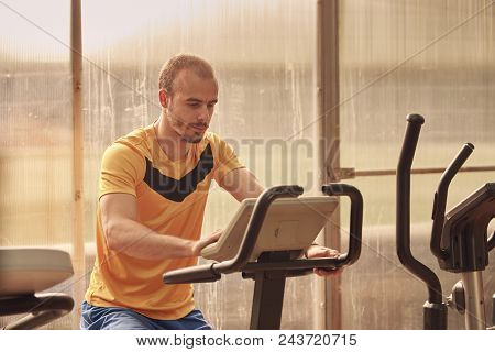 one young man, 25 years old, gym training on bike