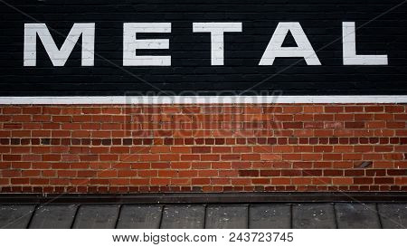 Metal Sign On Antique Brick Wall Above Awning Along Rural City Street