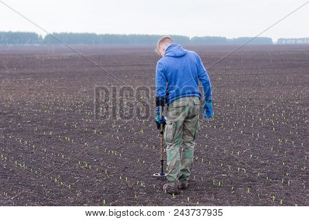Man To Seek Treasure On Earth With A Metal Detector, Walks The Field, Squeak Gold