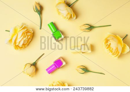 Nail Polish Bottle And Yellow Roses On Yellow Background. Trendy Manicure Concept, Pure Colors.