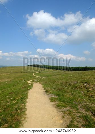 A Long Winding Footpath Running Into The Distance In Stoodley Moor In Yorkshire With Fields And Farm