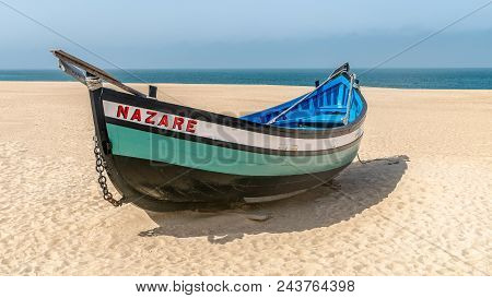 Colorful Traditional Old Wooden Fishing Boat On The Beach Of Fishing Village Of Nazare