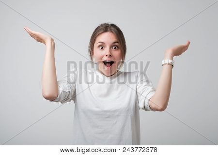 Pretty Young European Woman In White T-shirt Is Excited And Happy To Know Good News. Studio Photo.