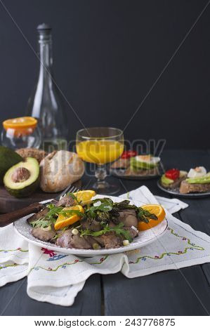A Delicious Healthy Dinner, A Warm Chicken Liver Salad With Oranges And Rucola, On A Black Wooden Ba