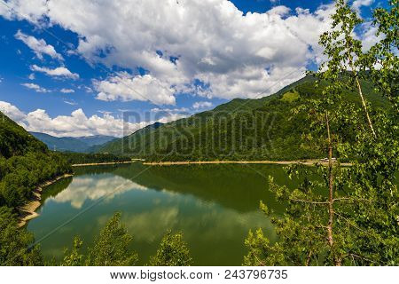 Landscape With Olt River In Romania Surrounded By Forest And Mountains