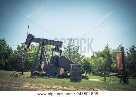 Vintage Tone Working Pump Jack Pumping Crude Oil At Oil Drilling Site In Rural Usa