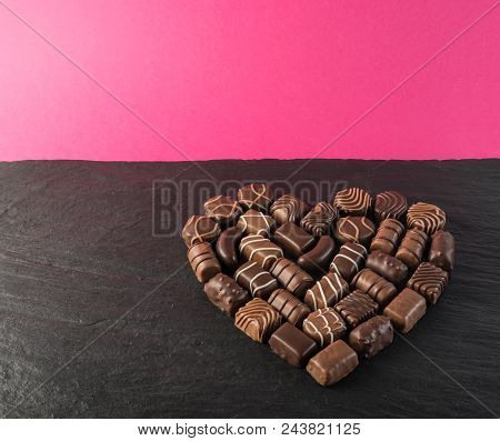 Beautiful Creative Chocolate Heart Shape Made With Various Types Of Pralines Over An Black Stone Bac