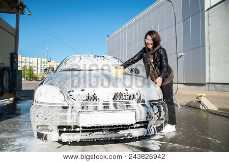 Young Woman Washing Car At Self-service Carwash
