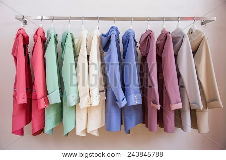 Colorful softshell coats on rack with hangers. Fashion conception.