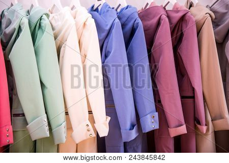 Colorful softshell coats on rack with hangers. Fashion conception.