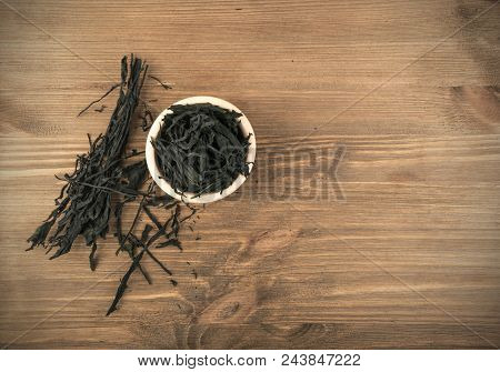 Heap Of Dry Wakame Seaweed On Wooden Background. Healthy Algae Food With Place For Text