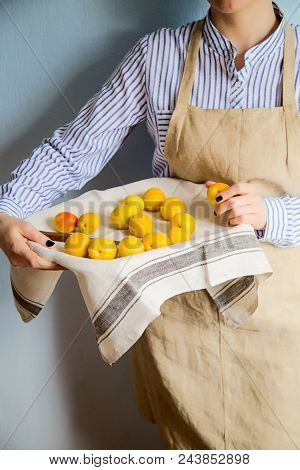 A Man Is Holding A Tray Fukk Of Fresh Apricots And Peaches From The Garden.