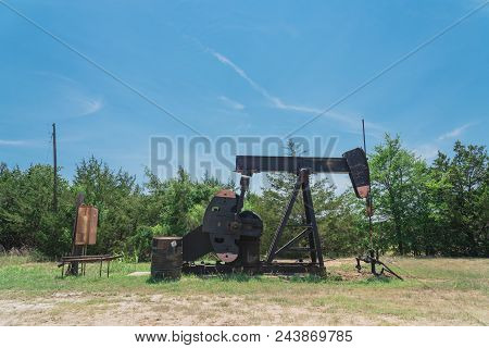 Working Pump Jack Pumping Crude Oil At Oil Drilling Site In Rural Usa