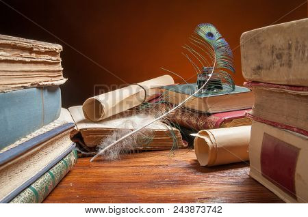 Green Quil Pen And Black Inkwell With Old Papers And Books