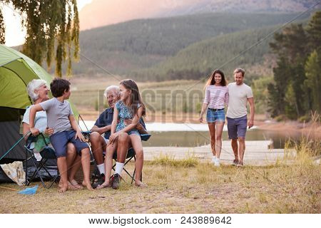 Multi Generation Family On Camping Trip By Lake Together