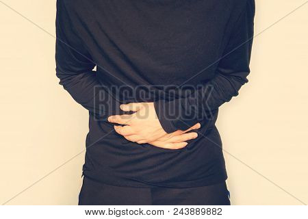 Young Man Having A Stomachache. Abdominal Pain. A Man Holds A Big Belly. Fermentation In The Intesti