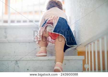 Little Cute Toddler Girl Climbing On Stairs At Home. Baby Learning And Making First Steps, High Stai