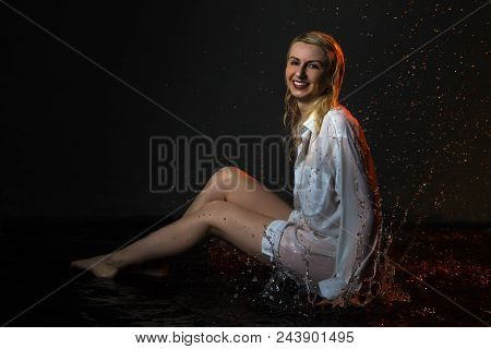 Nice Girl In The White Shirt And Water Drops Behind And Arround Her Illuminated By Light During A Ph