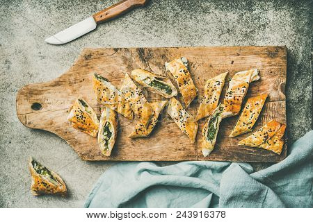 Flat-lay Of Fresh Turkish Borek Roll With Spinach, Feta Cheese, Black Cumin Seeds Cut In Slices On R