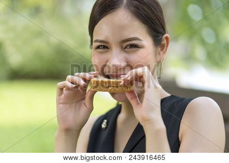 Asian Woman Eating With Whole Wheat Sandwich Bread With Chocolate Sauce.