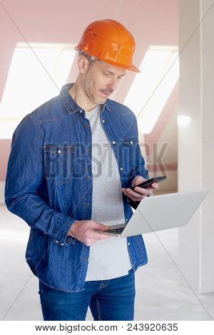 Construction Worker Using Laptop And Mobile Phone