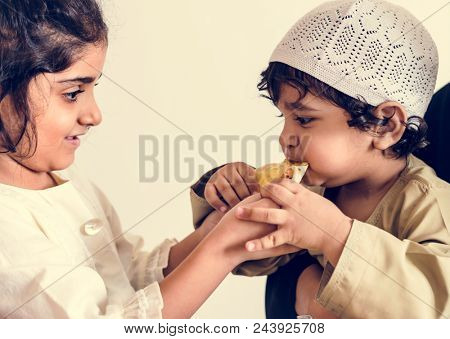Sister sharing pita bread with her brother