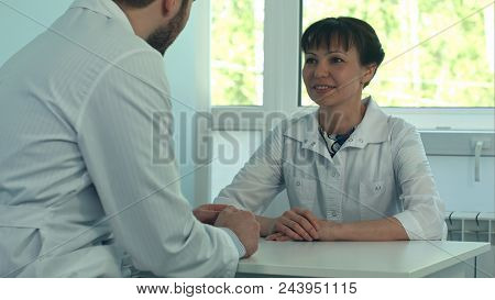 Two Doctors Discussing And Working Together In A Medical Office