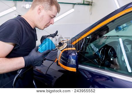 A Man Is Polishing A Blue Car. Polishing Machine And Polishing Paste For Gloss.