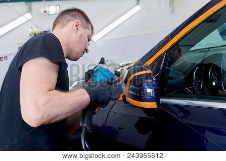 A Man Is Polishing A Blue Car. Polishing Machine And Polishing Paste For Gloss.