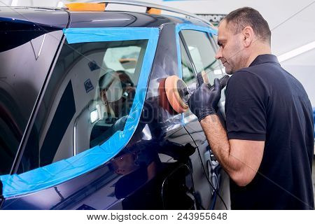 A Man Is Polishing A Blue Car. Polishing Machine And Polishing Paste For Gloss.