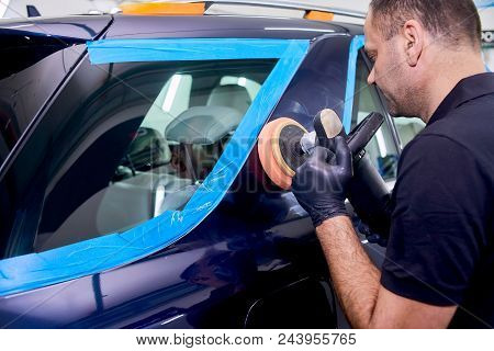 A Man Is Polishing A Blue Car. Polishing Machine And Polishing Paste For Gloss.