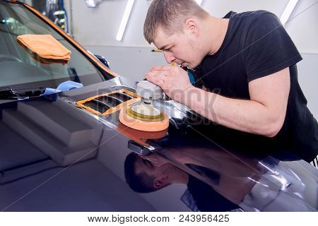 A Man Is Polishing A Blue Car. Polishing Machine And Polishing Paste For Gloss.
