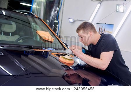 A Man Is Polishing A Blue Car. Polishing Machine And Polishing Paste For Gloss.