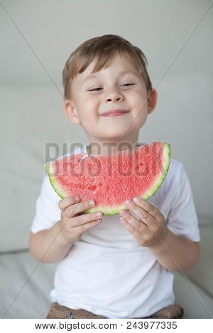 A Small Cute Boy 4 Years Old Is Eating A Watermelon. Summer. Heat. Watermelon. Portrait Of A Happy B