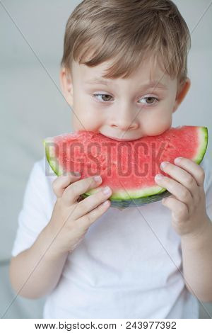 A Small Cute Boy 4 Years Old Is Eating A Watermelon. Summer. Heat. Watermelon. Portrait Of A Happy B