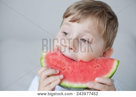 A Small Cute Boy 4 Years Old Is Eating A Watermelon. Summer. Heat. Watermelon. Portrait Of A Happy B