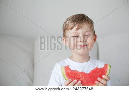 A Small Cute Boy 4 Years Old Is Eating A Watermelon. Summer. Heat. Watermelon. Portrait Of A Happy B