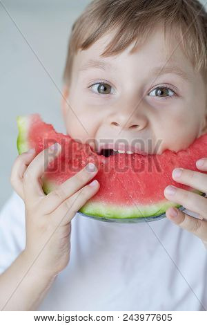 A Small Cute Boy 4 Years Old Is Eating A Watermelon. Summer. Heat. Watermelon. Portrait Of A Happy B