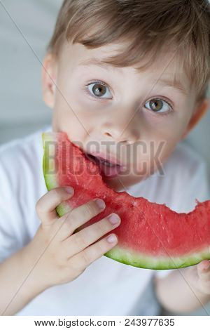 A Small Cute Boy 4 Years Old Is Eating A Watermelon. Summer. Heat. Watermelon. Portrait Of A Happy B