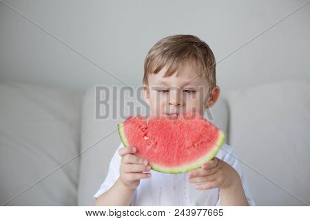 A Small Cute Boy 4 Years Old Is Eating A Watermelon. Summer. Heat. Watermelon. Portrait Of A Happy B