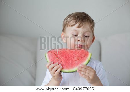 A Small Cute Boy 4 Years Old Is Eating A Watermelon. Summer. Heat. Watermelon. Portrait Of A Happy B