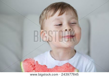 A Small Cute Boy 4 Years Old Is Eating A Watermelon. Summer. Heat. Watermelon. Portrait Of A Happy B