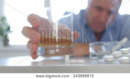 Upset Man Drinking Alcohol Mixed With Medication